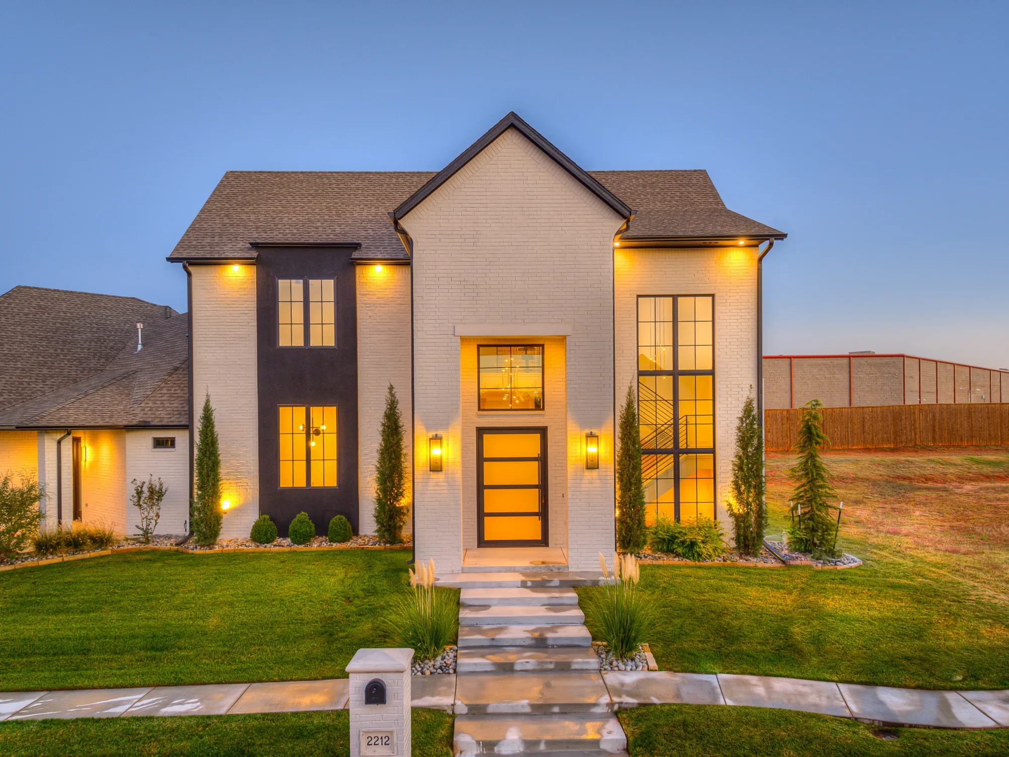 Custom home exterior illuminated at dusk