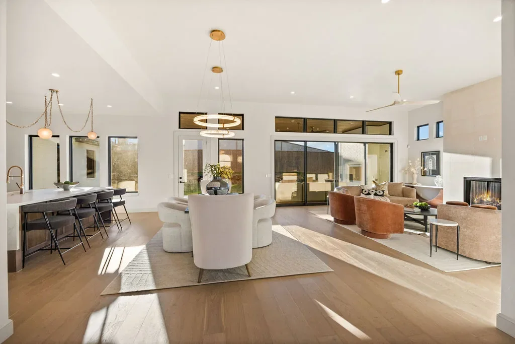 Open kitchen and living area with brass lighting and warm wood floors