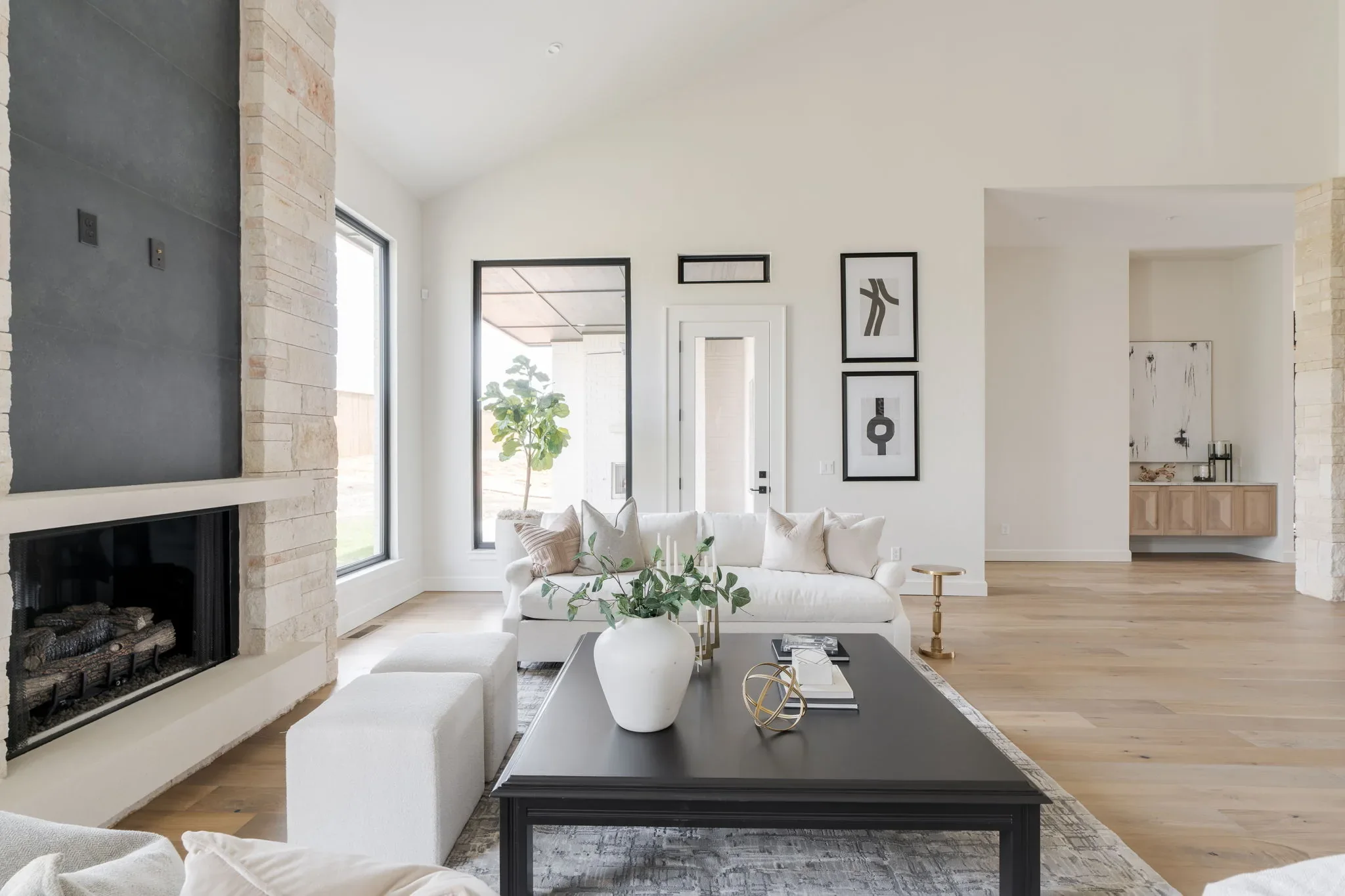 Living room with a floor-to-ceiling stone fireplace and tall windows