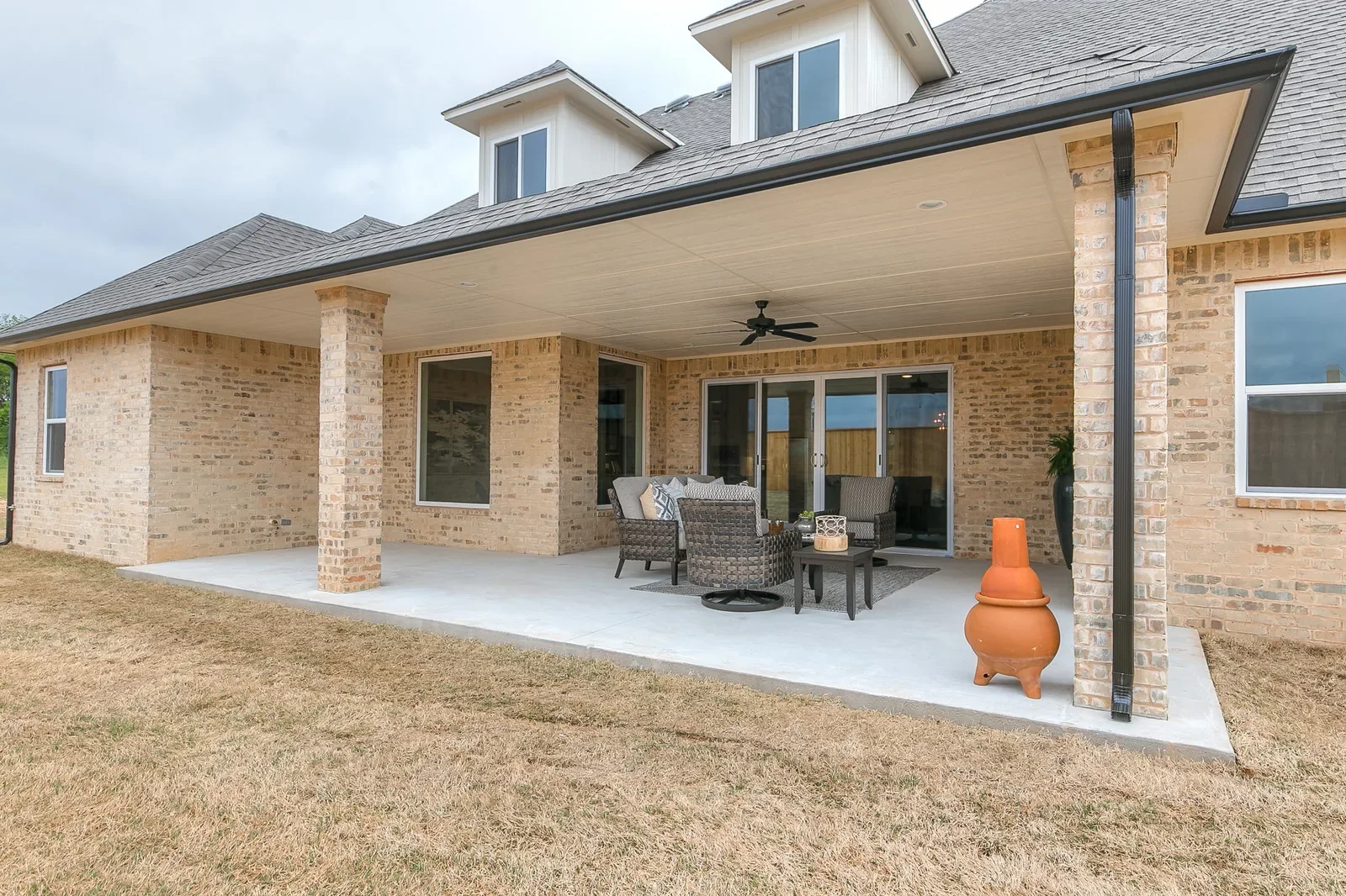 Covered rear patio with brick columns and outdoor seating