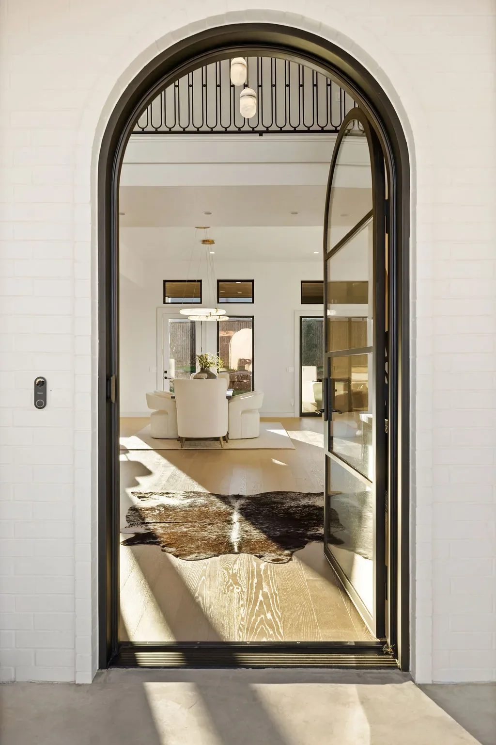 Arched glass front door opening into the bright foyer