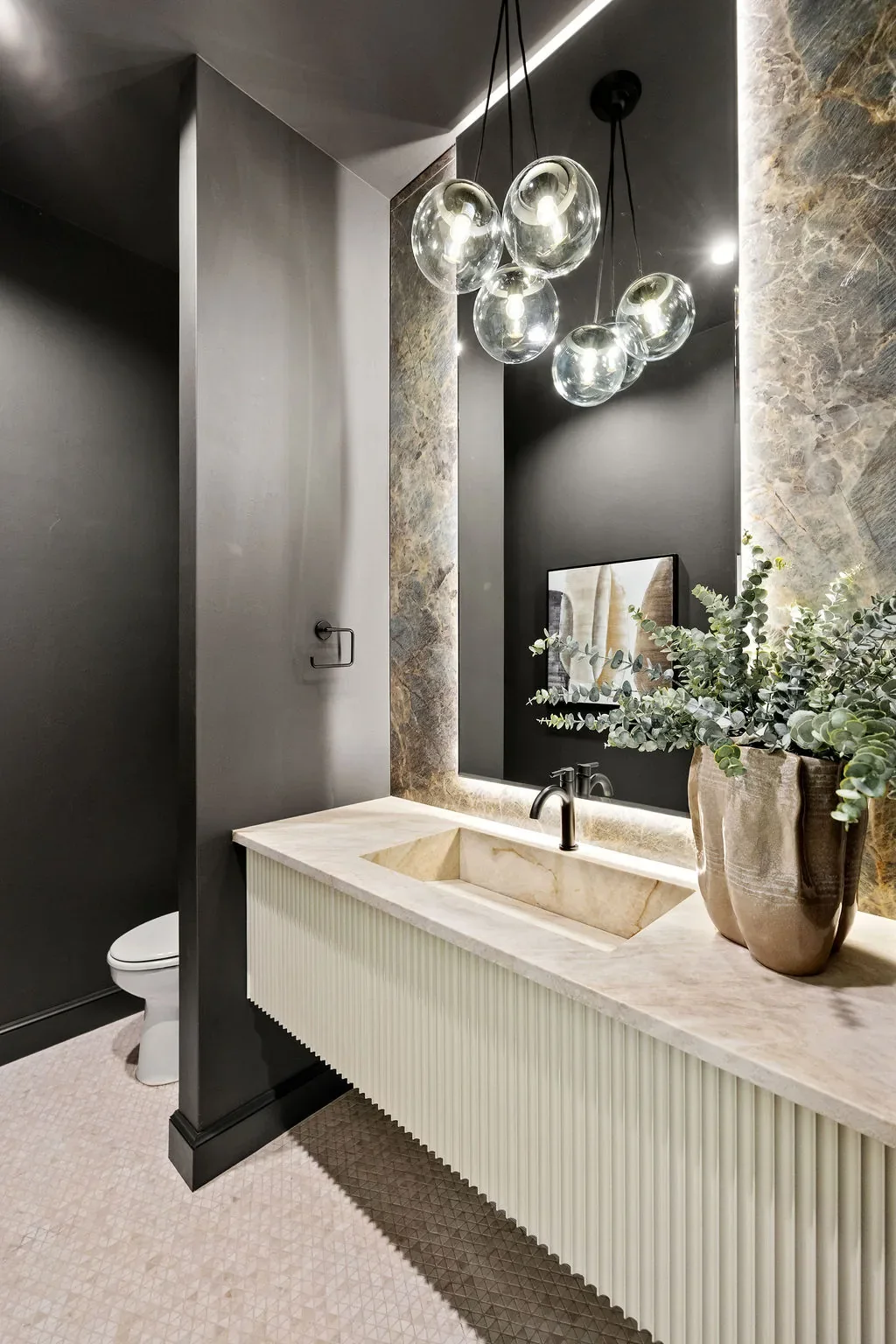Dark powder room with fluted vanity and clustered glass pendants