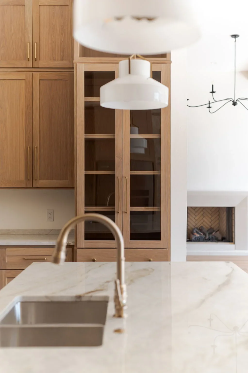 Kitchen island sink with oak cabinetry and the living room beyond
