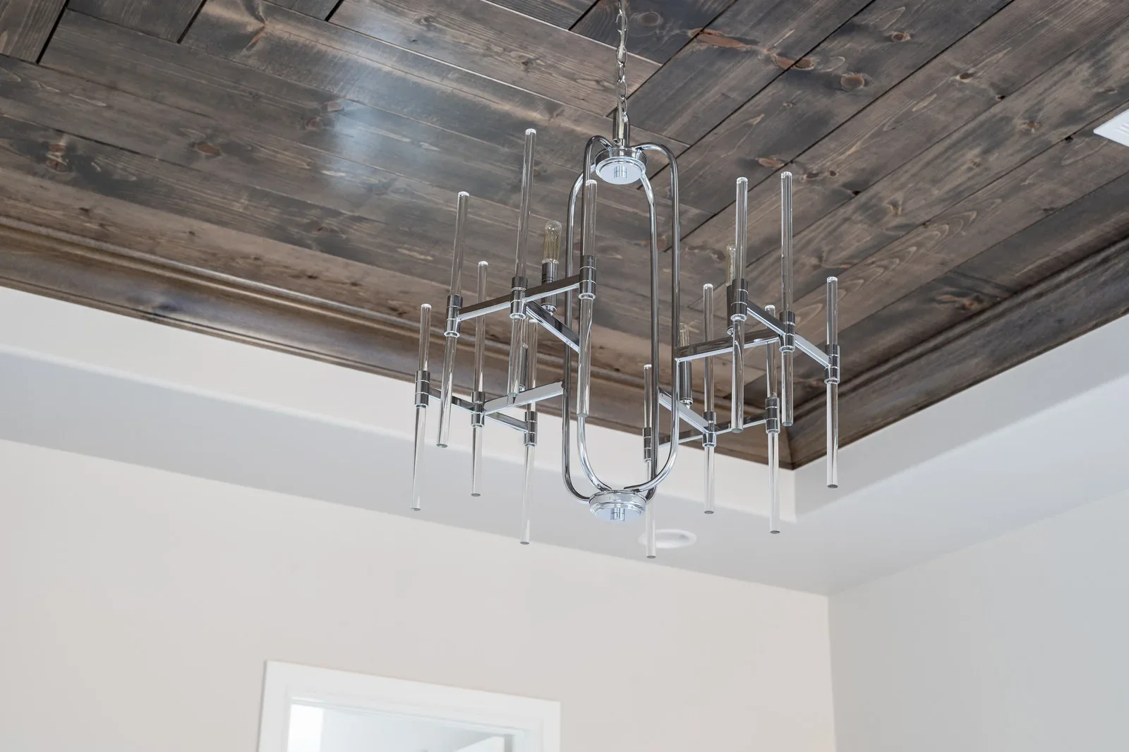 Wood-paneled tray ceiling with geometric metal chandelier