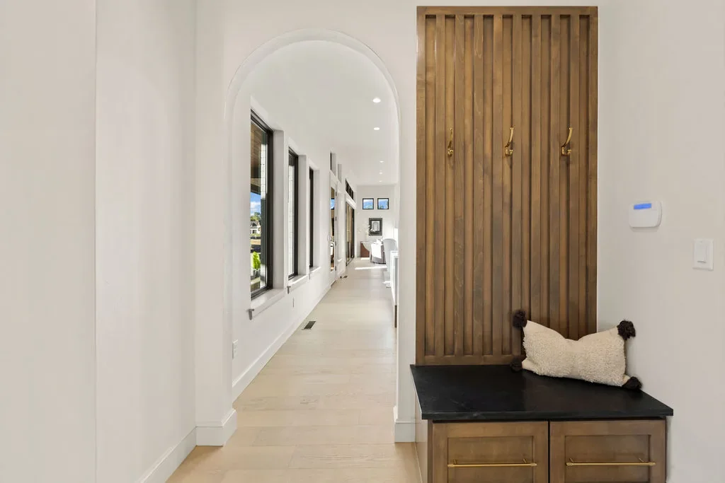 Mudroom with slatted wood bench and full-height cabinetry