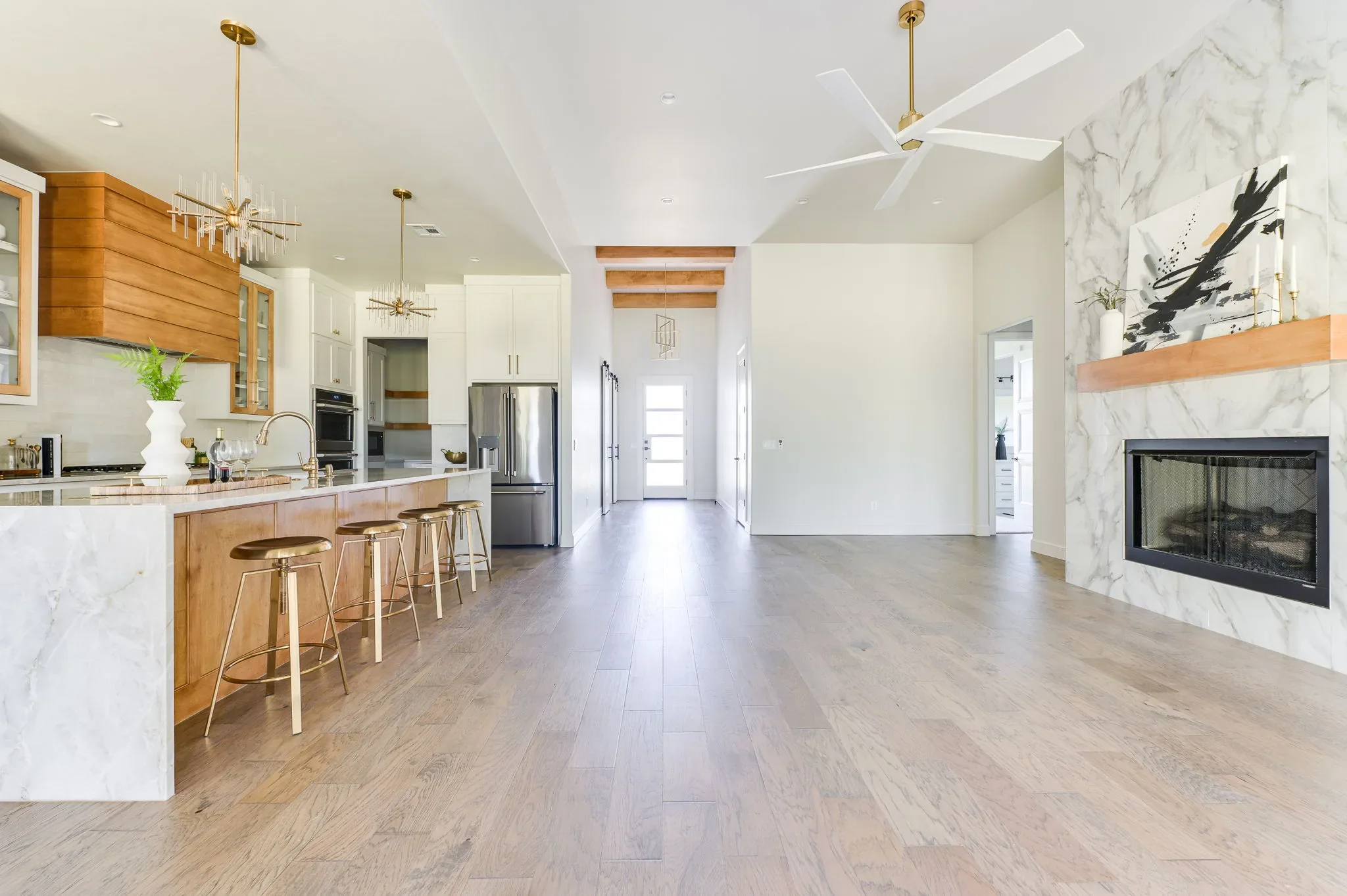 Open kitchen and great room with a marble fireplace