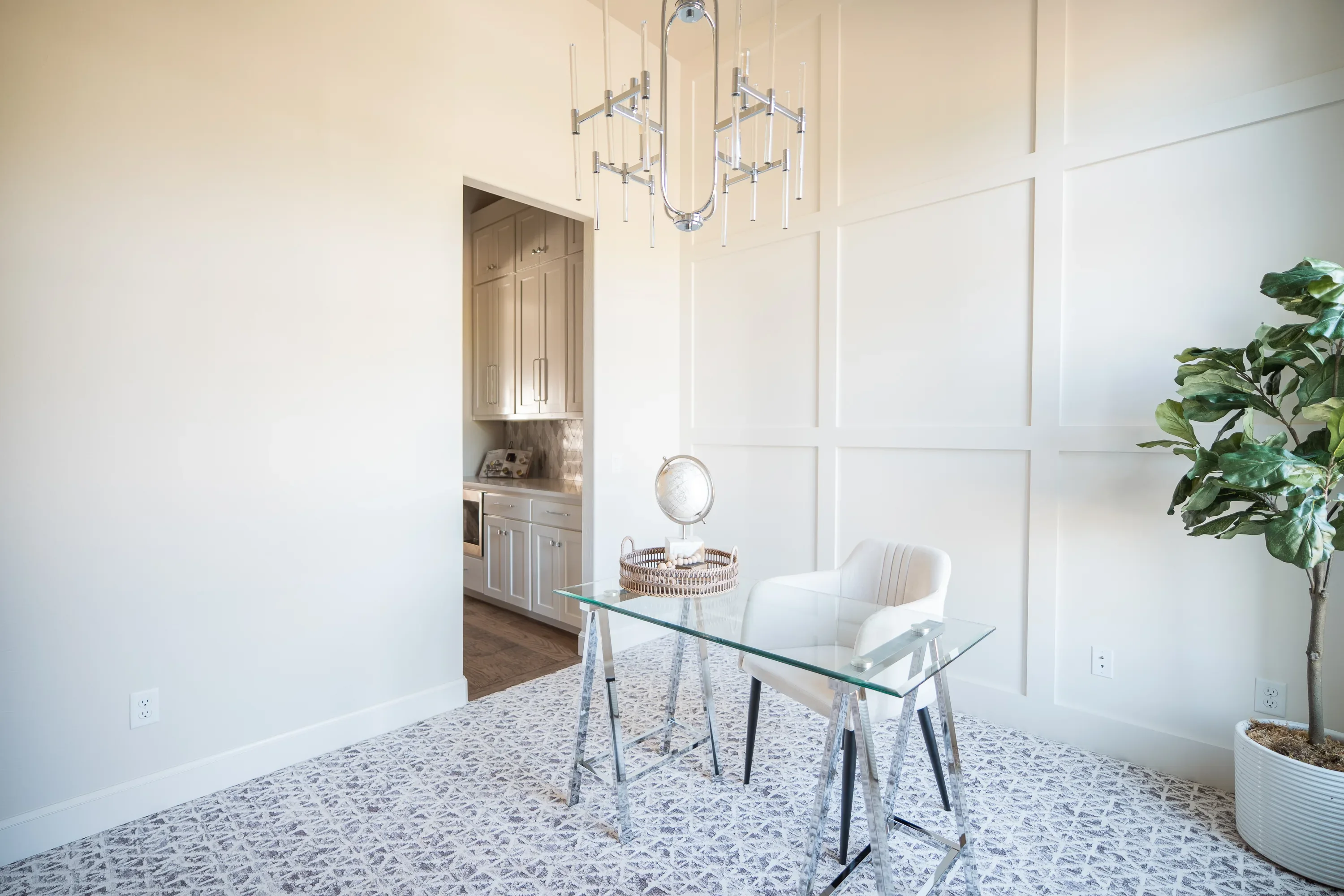 Home office with paneled wall and modern glass desk