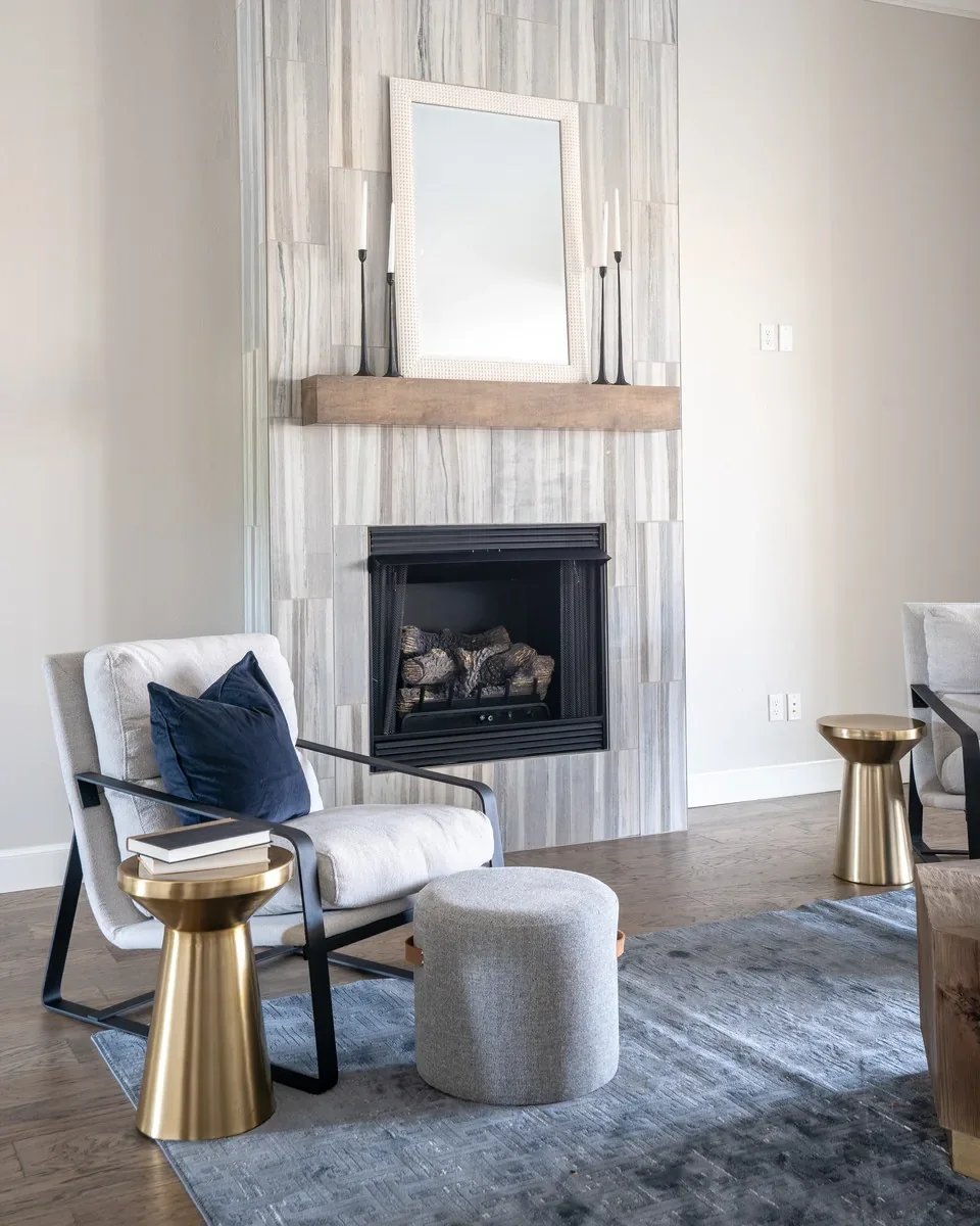 Living room seating arranged around the tall tiled fireplace