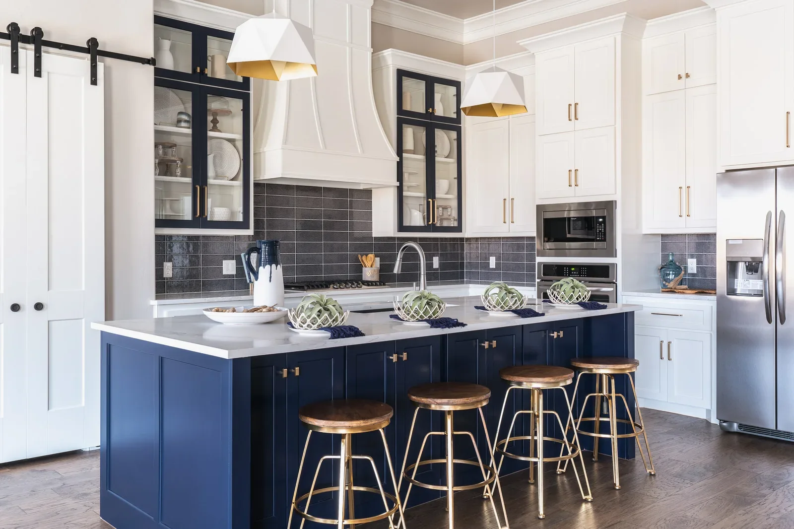White kitchen with navy island and black tile backsplash