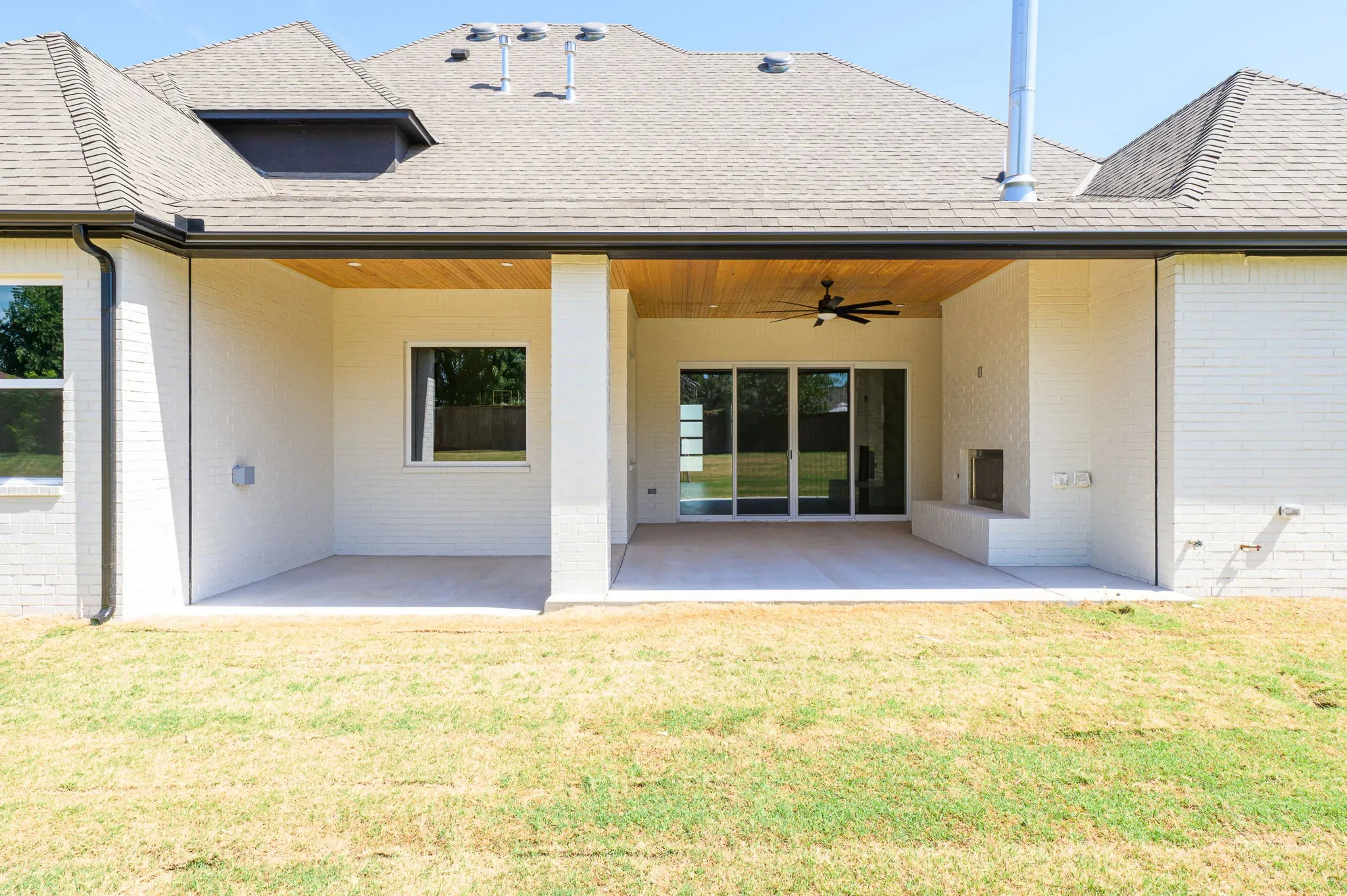 Rear exterior with a covered patio and open lawn
