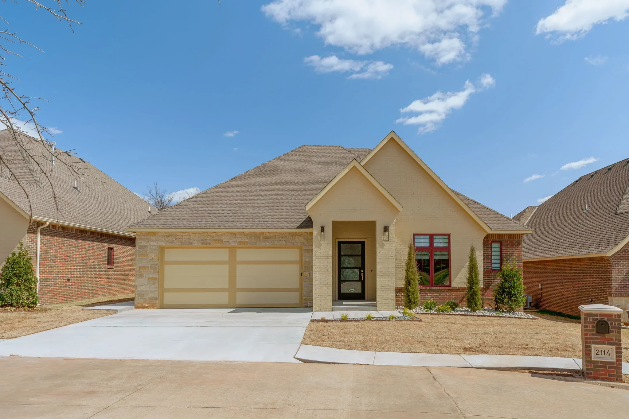 Front exterior of 2114 Rockbridge Mill Ln with brick, stone, and a paneled garage