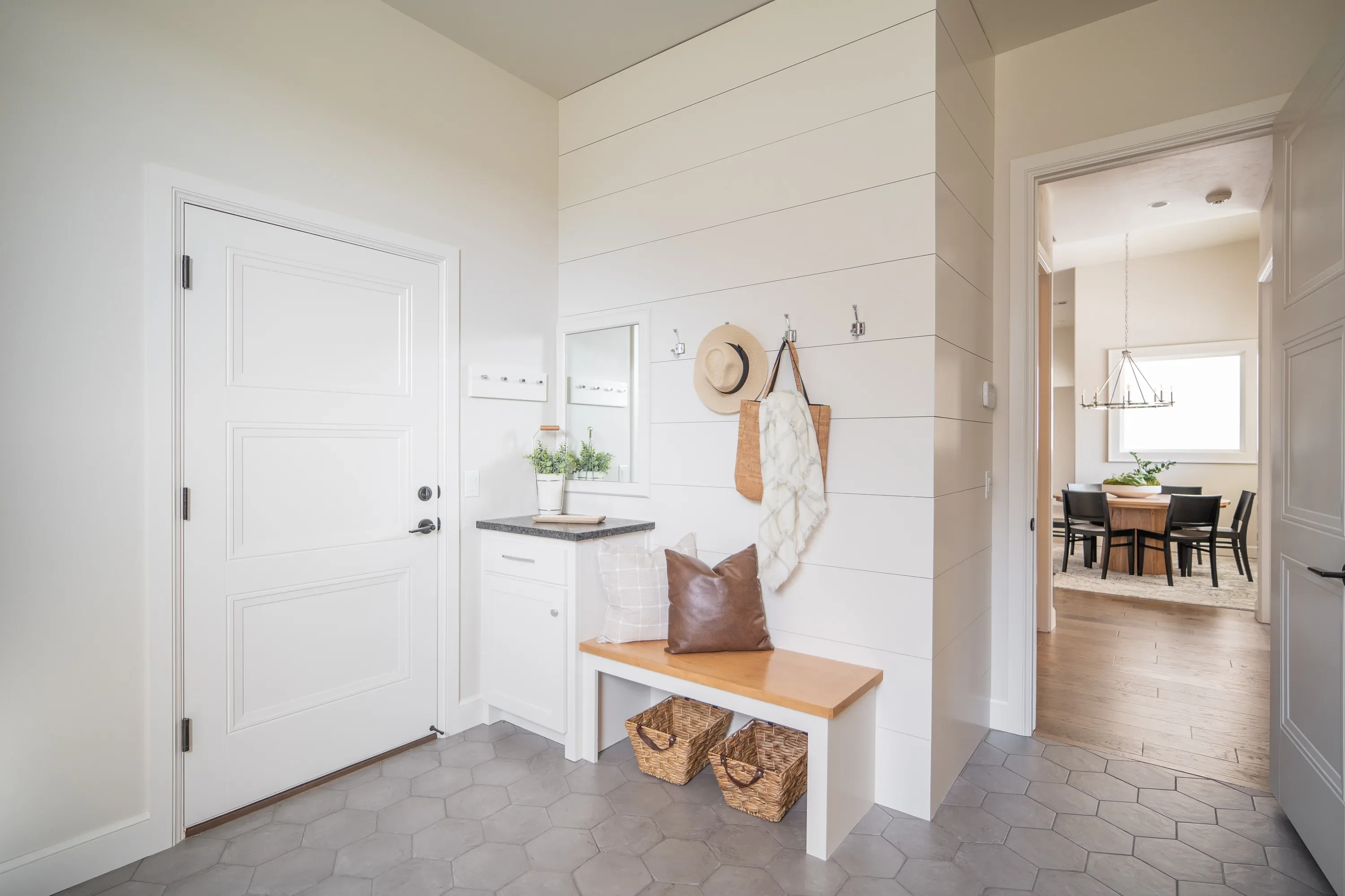 Mudroom entry with built-in bench, hooks, and hex tile