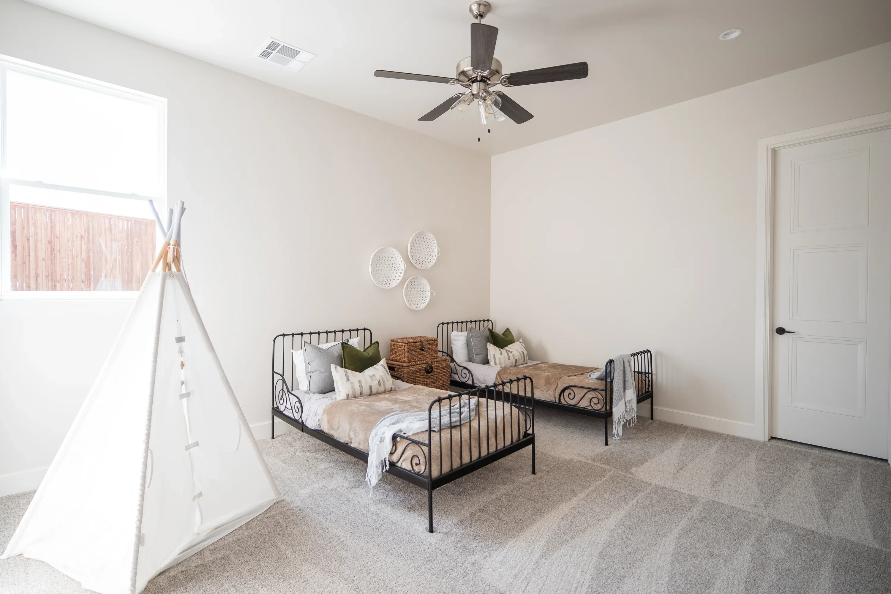 Children's bedroom with twin daybeds and a play tent
