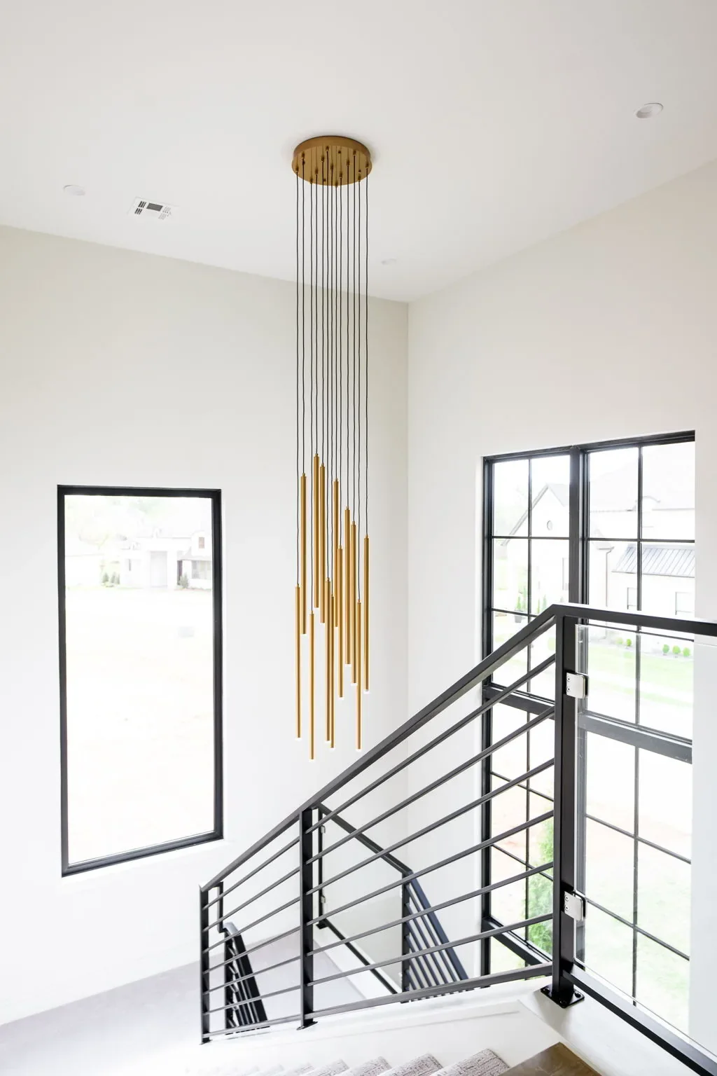 Floating staircase and brass pendant viewed from the upper landing