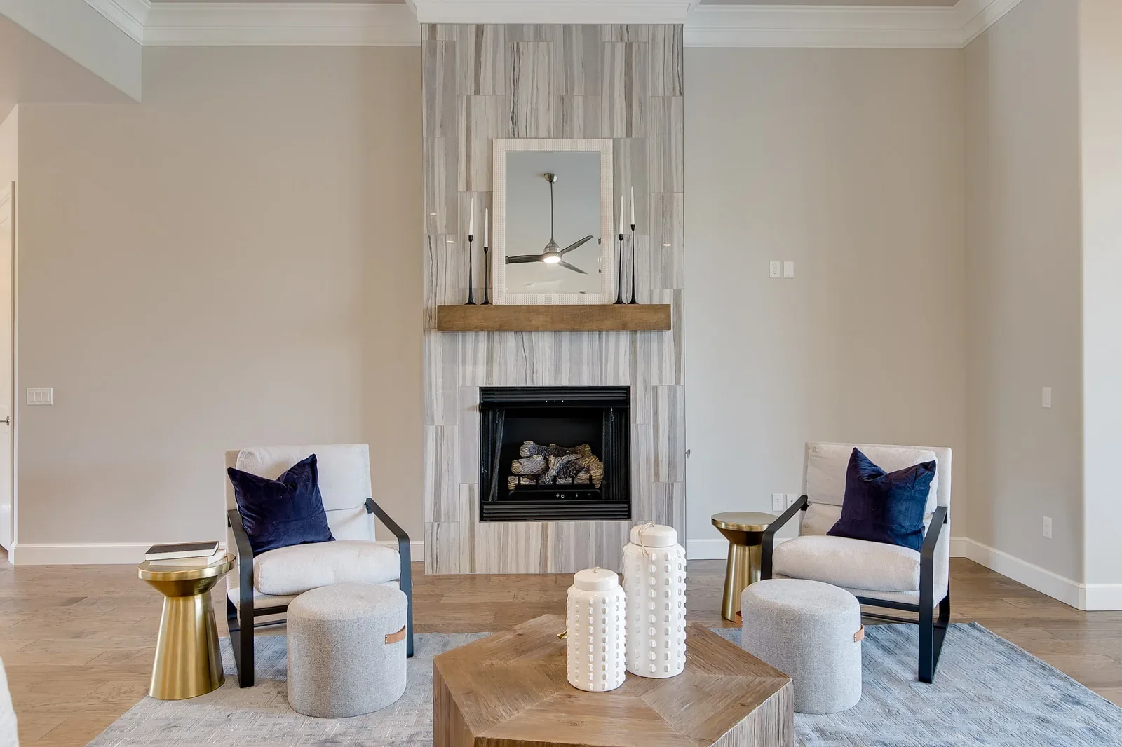 Living room with tall tiled fireplace and warm wood mantel