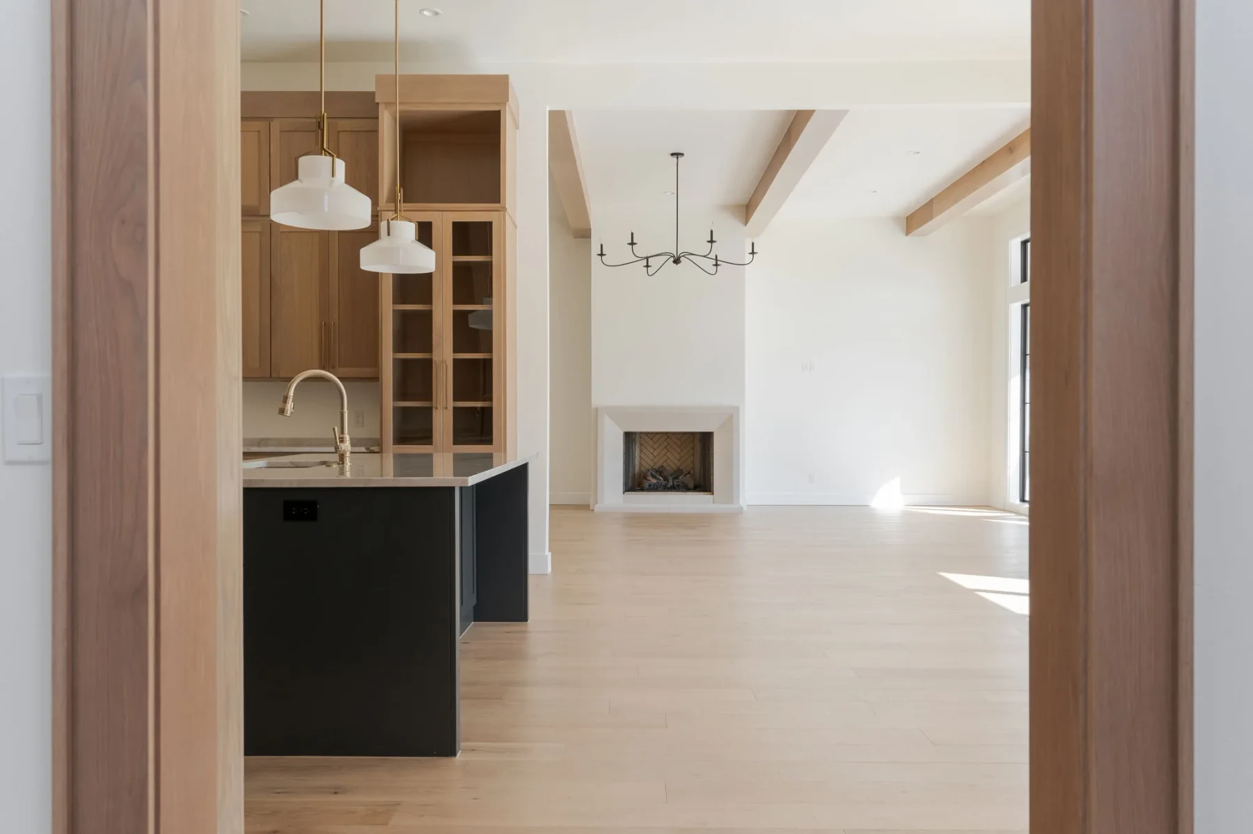 View through the kitchen toward the living room fireplace and exposed beams