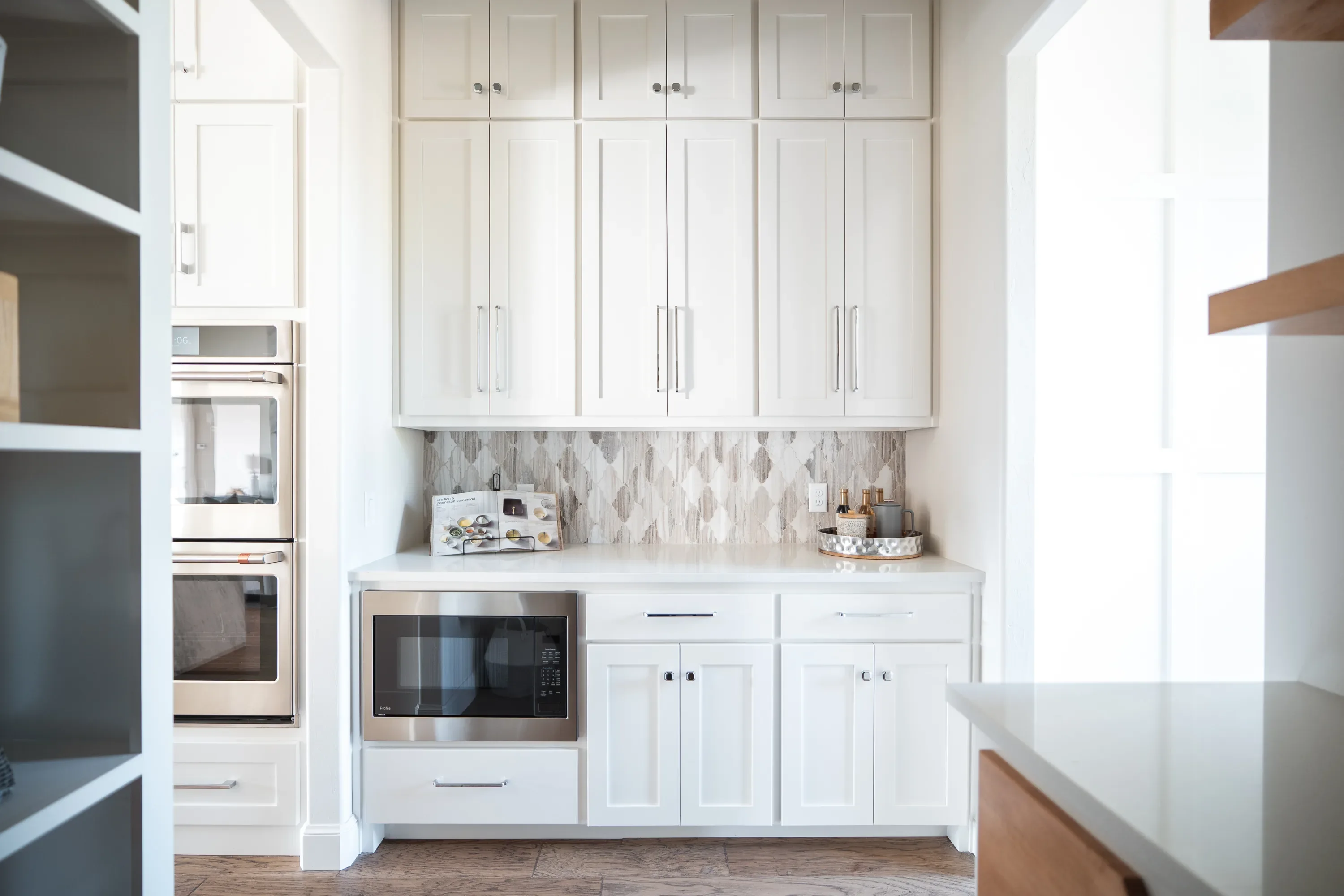 White beverage station with patterned backsplash and appliance storage