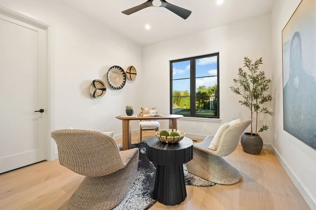 Home office with woven lounge chairs and a wood desk