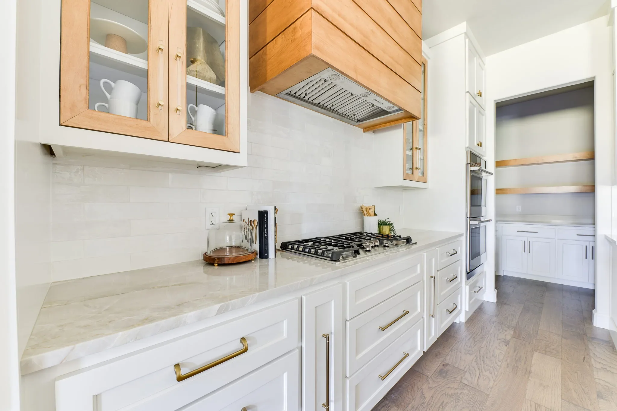 Gas range and white cabinetry leading into the prep pantry