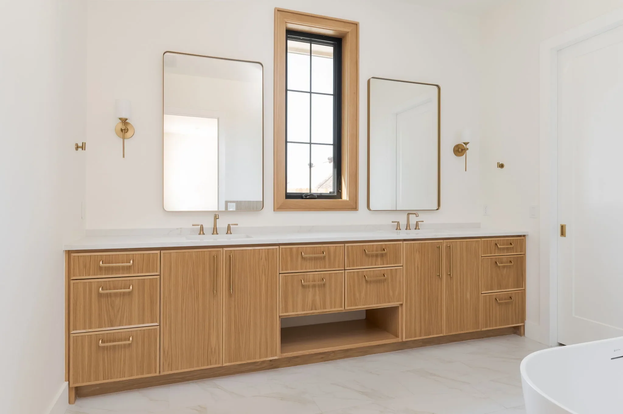 Primary bathroom with an oak double vanity and black-framed window