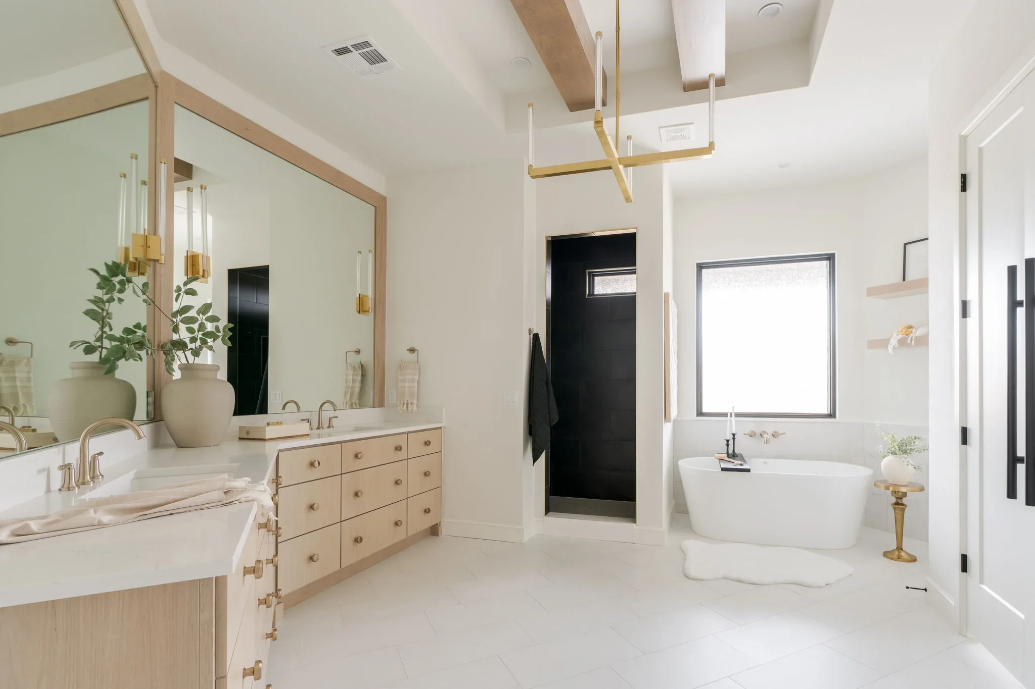 Primary bathroom with an oak double vanity and freestanding tub