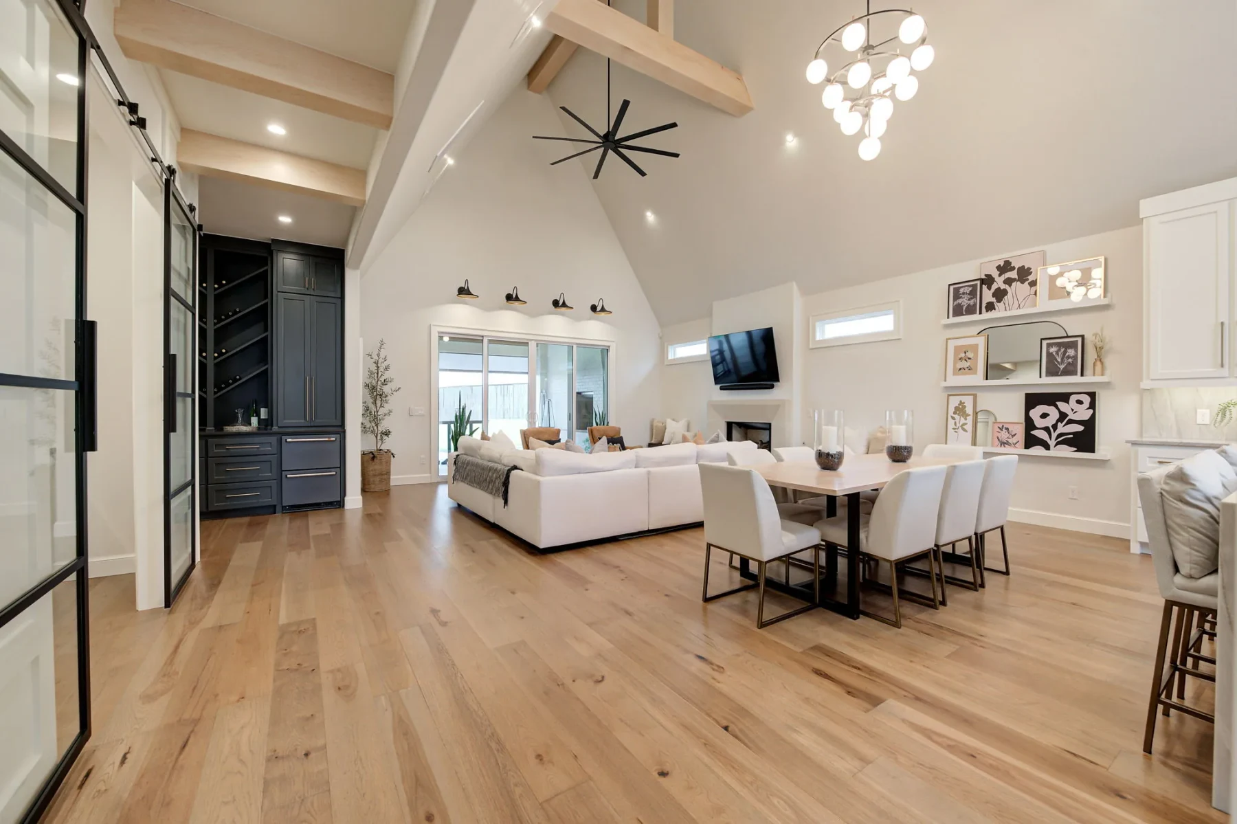 Vaulted open living and dining room with exposed wood beams
