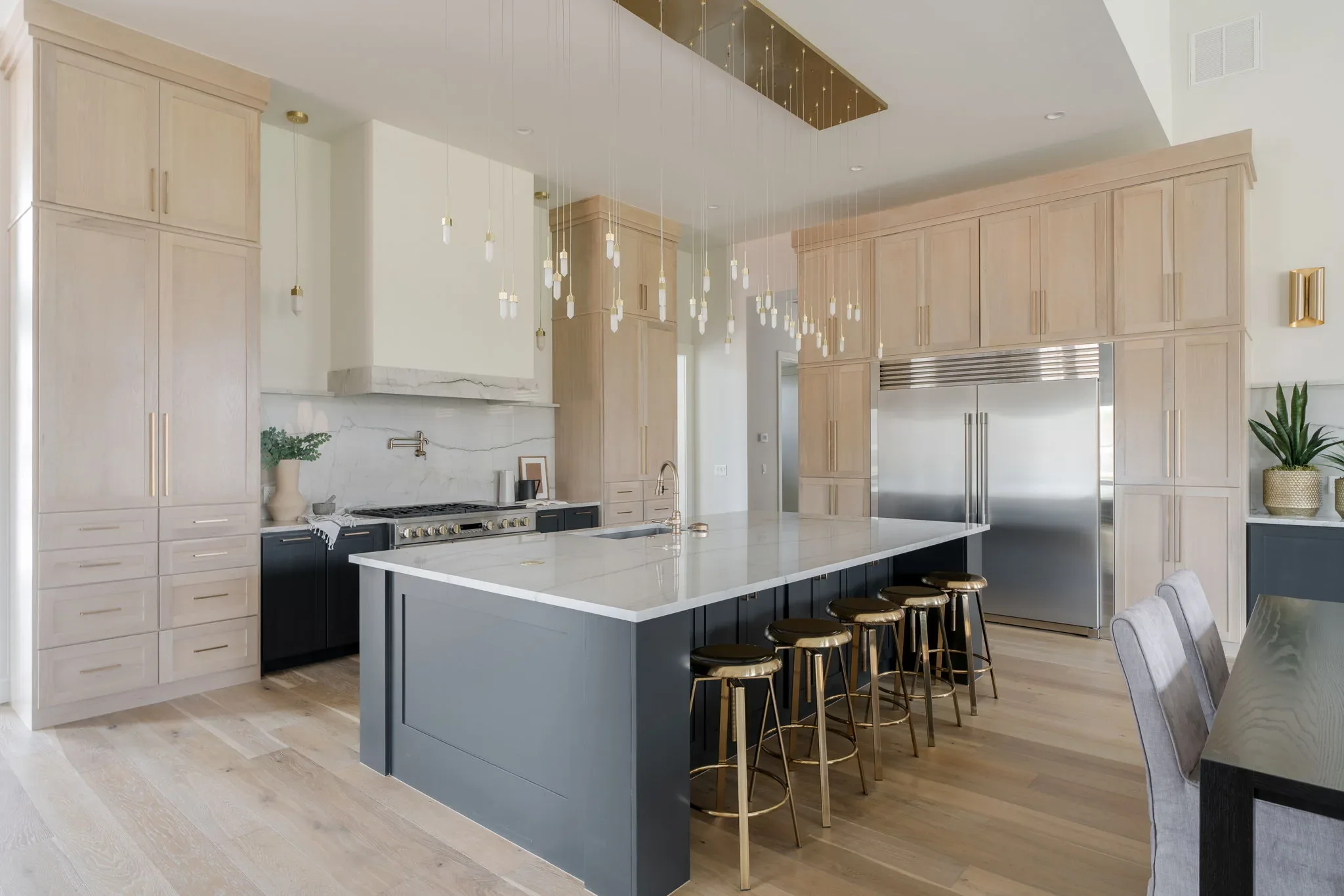 White oak kitchen with a charcoal island and waterfall countertop