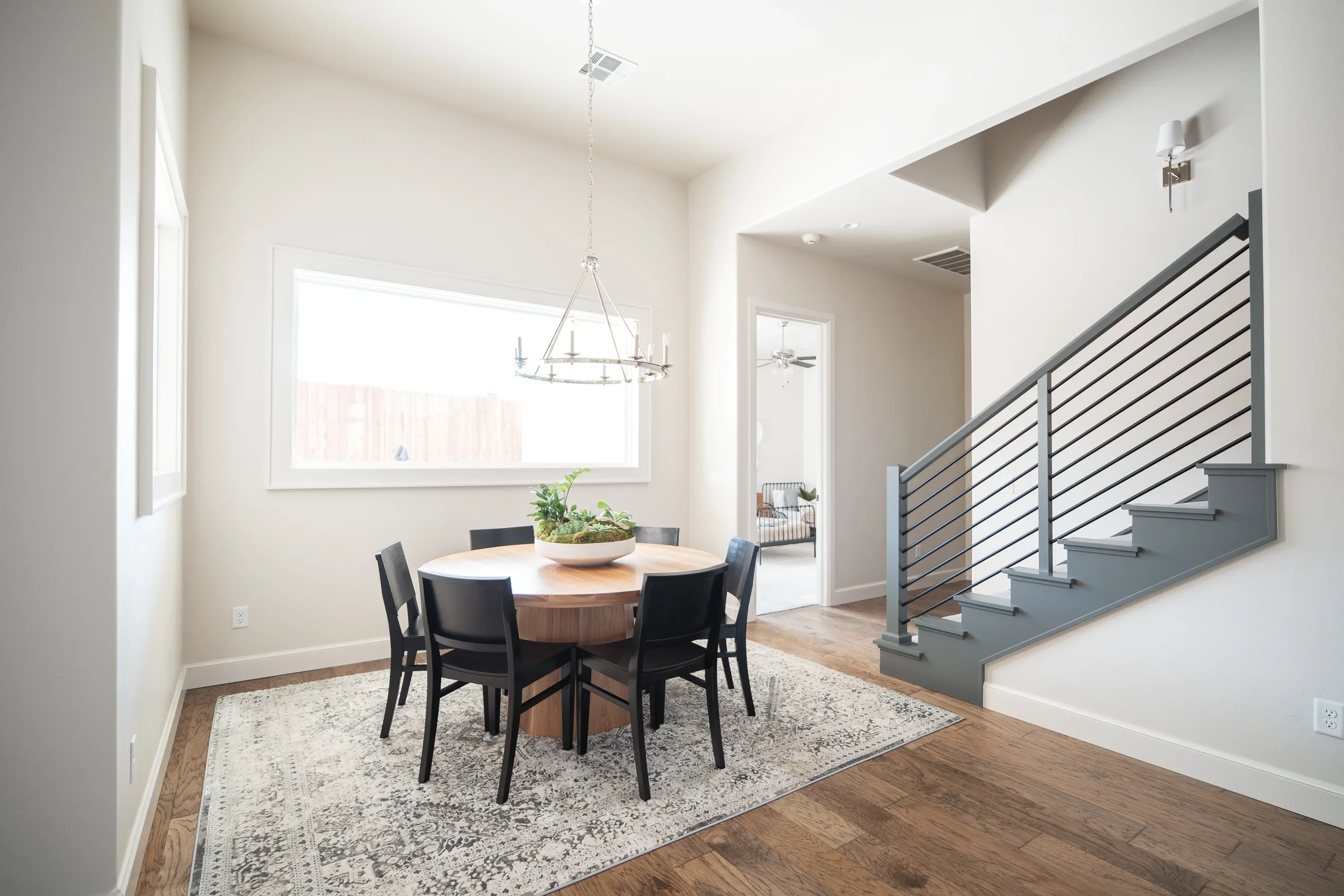 Dining nook beside the modern black-railed staircase
