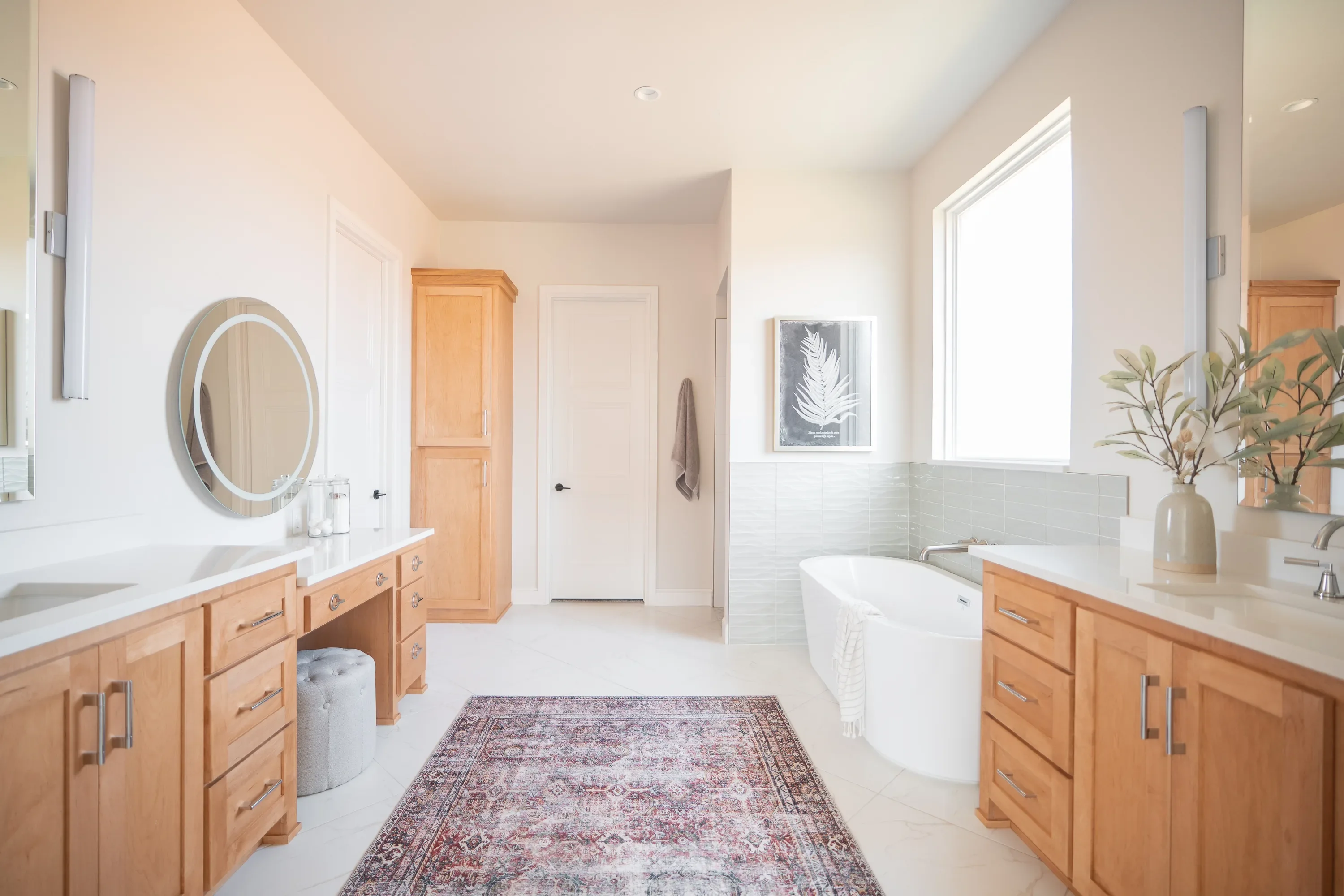 Primary bathroom with double wood vanities and freestanding tub